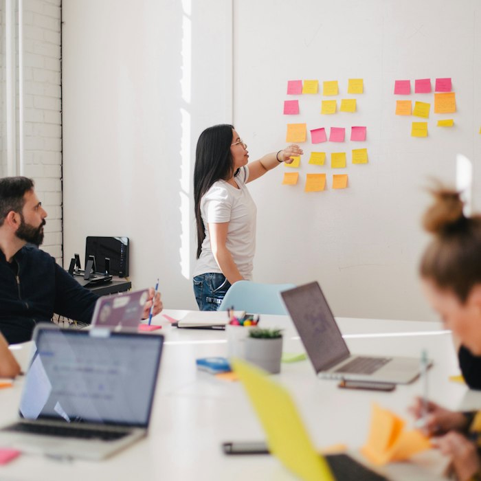 Team planning a marketing strategy with sticky notes on a whiteboard